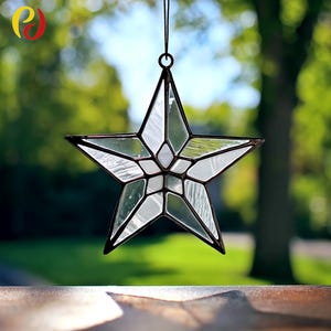 May include: A clear glass star-shaped suncatcher with a dark metal frame. The star is divided into geometric sections, creating a stained-glass effect. It hangs from a black cord, perfect for window or wall decor.