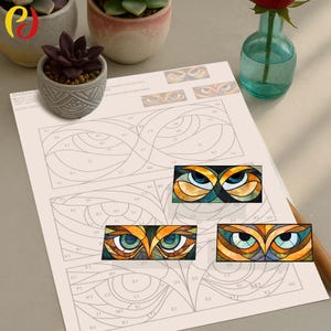 Peut inclure: Une feuille avec un motif d'yeux de hibou en vitrail, avec un crayon et de petites plantes en pot. Le motif présente des formes géométriques et des couleurs comme le bleu, l'orange et le vert. La feuille a un quadrillage avec des lettres et des chiffres.