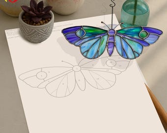 May include: A stained glass butterfly with blue, green, and purple glass pieces. The butterfly is numbered 1 through 14, suggesting it is a craft project. The butterfly is on a white sheet of paper with a pencil and a drawing of a butterfly.