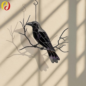 May include: A stained glass raven perched on a branch, hanging from a chain. The raven is black with purple and silver accents. The branch is dark brown, and the background is a light beige wall with shadows.