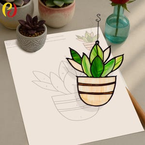 May include: A stained glass succulent plant hanging ornament with green and white leaves in a cream and brown pot. The ornament is hanging from a black chain with a silver hook.