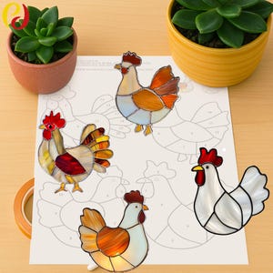 May include: Four stained glass rooster figurines in various colors, including red, orange, yellow, and white, are displayed on a paper pattern. The roosters have detailed features and are surrounded by potted succulents.