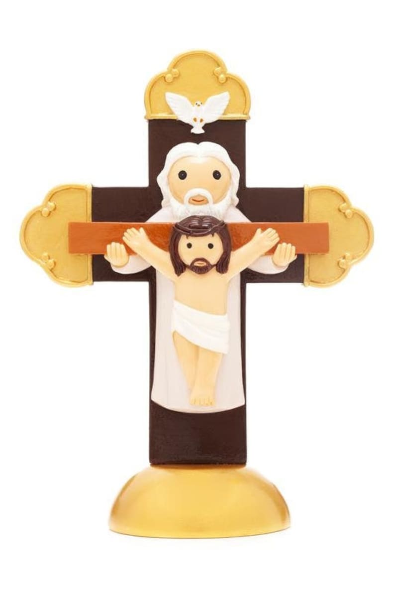 May include: A brown wooden cross with a gold base. A white figure of Jesus is on the cross with a white dove above. The figure of Jesus has a white cloth around the waist.