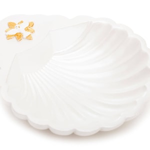 May include: White ceramic seashell dish with a gold dove design. The dish is perfect for holding small items like jewelry or trinkets.