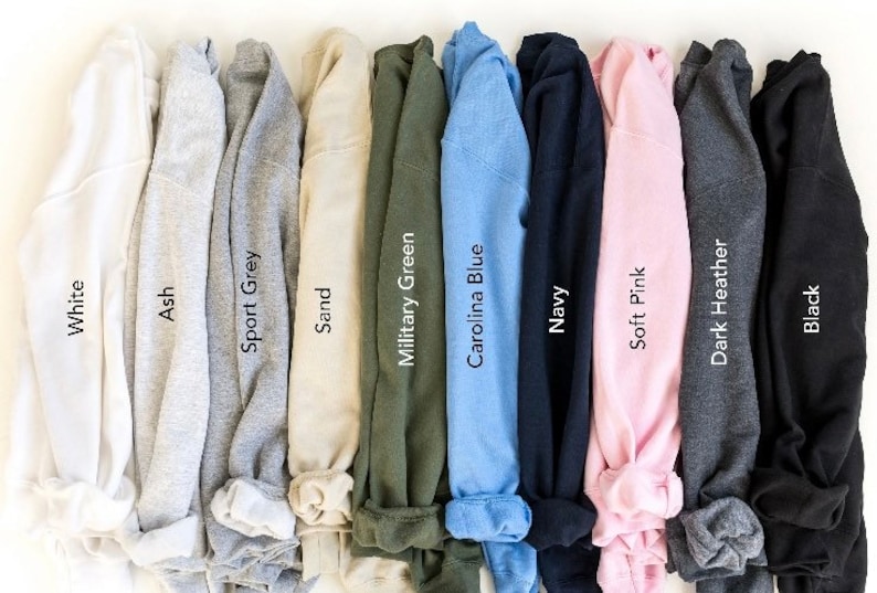 Puede incluir: Una selecci&oacute;n de diez camisetas dobladas en varios colores, incluyendo blanco, ceniza, gris deportivo, arena, verde militar, azul Carolina, azul marino, rosa suave, gris oscuro y negro.