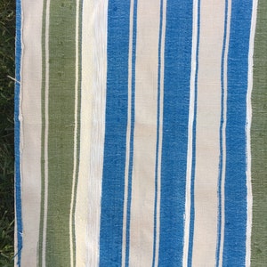 Puede incluir: Una tela rayada con rayas verdes, blancas y azules. La tela est&aacute; tejida y tiene una textura rugosa.
