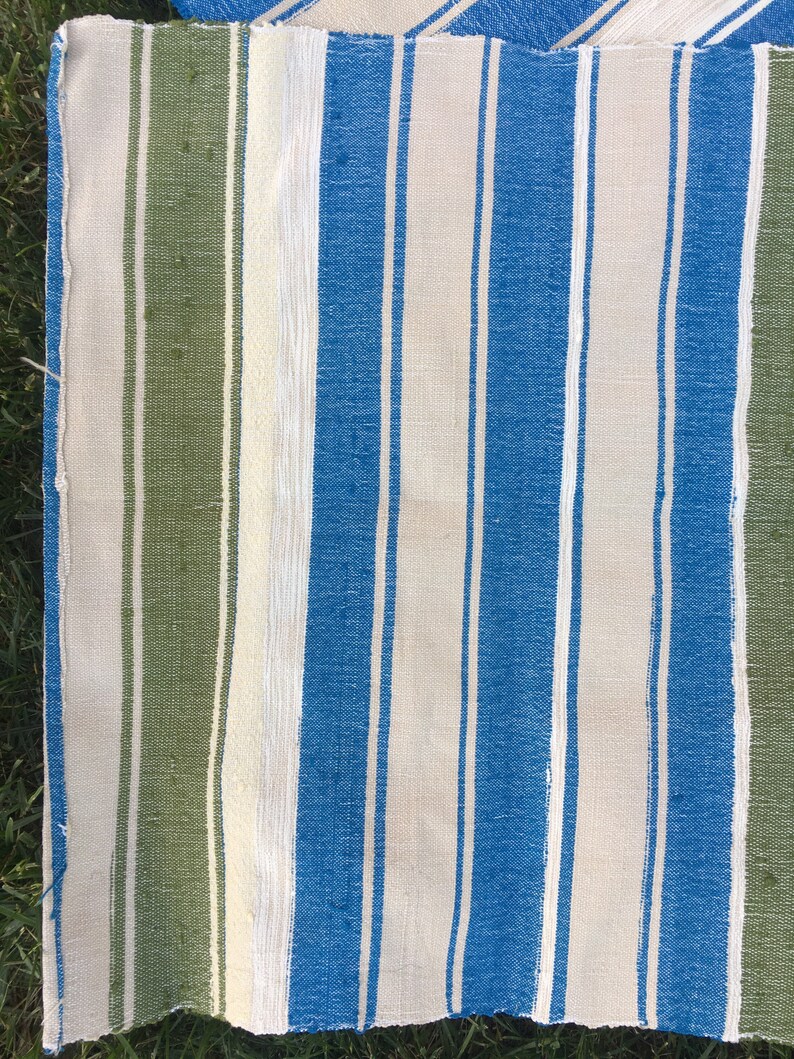 Puede incluir: Una tela rayada con rayas verdes, blancas y azules. La tela est&aacute; tejida y tiene una textura rugosa.
