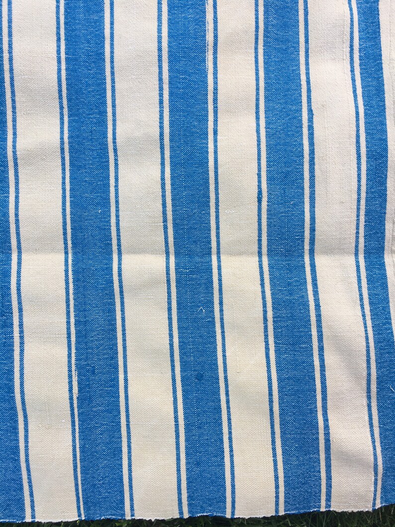 Puede incluir: Una tela de rayas blancas y azules con textura tejida. La tela tiene un brillo sutil y est&aacute; hecha de fibras naturales.