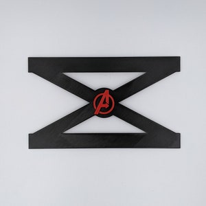 May include: Black plastic stand with a red and white Avengers logo in the center. The stand is shaped like an X.