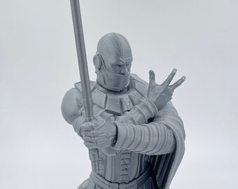 May include: A gray 3D printed bust of Darth Malak from Star Wars: Knights of the Old Republic. The bust is holding a lightsaber and has a detailed sculpt of his armor and face.