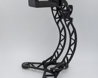 May include: A black 3D printed stand with a curved arm for holding headphones. The stand has a triangular base with three legs.