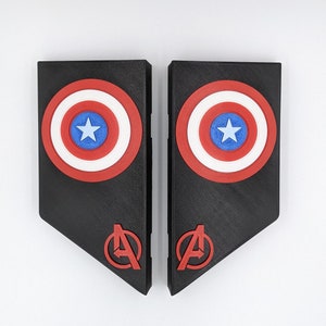 May include: Two black 3D printed panels with a red, white, and blue Captain America shield design and a red Avengers logo on each panel.