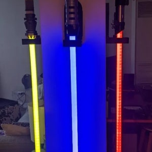 以下が含まれることがあります： 壁に取り付けられたライトセーバーのレプリカ3つ。黄色、青、赤のライトセーバーです。