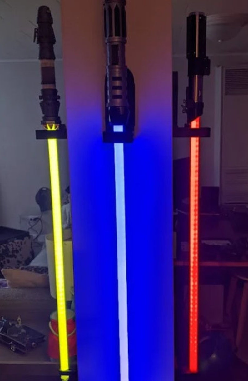 以下が含まれることがあります： 壁に取り付けられたライトセーバーのレプリカ3つ。黄色、青、赤のライトセーバーです。