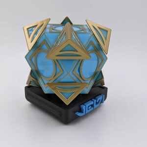May include: A blue and gold geometric sculpture with a black base. The base has the word "JEIZI" printed in blue.
