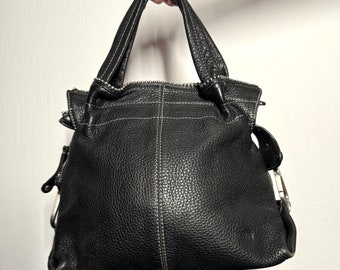 May include: Black leather tote bag with silver hardware and white stitching. The bag has a zipper closure and two top handles.