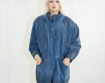 May include: A blue suede jacket with a diamond pattern and a zip closure. The jacket has two pockets on the front and a high collar.