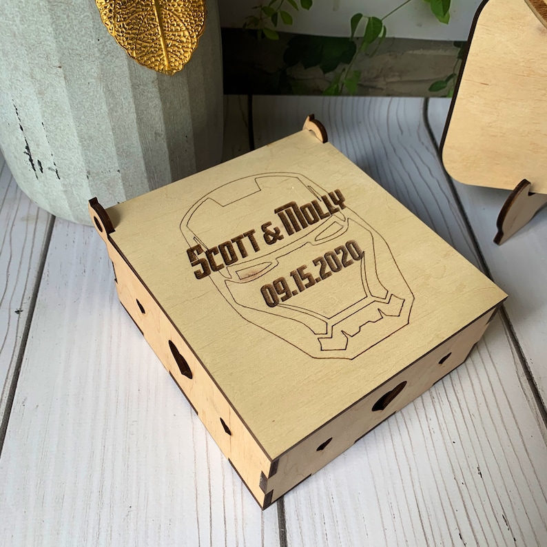 May include: A wooden box with a laser-engraved image of Iron Man's face. The box is personalized with the text "Scott & Molly 09.15.2020".