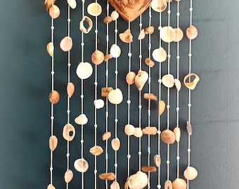 Beautiful wind and chime made from extravagant driftwood, turquoise and white pearls and various shells.