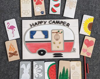 May include: A set of 15 wooden craft cutouts featuring a camper van, a campfire, a snowflake, a watermelon, a heart, a bunny, a beehive, a sunflower, a flamingo, and stars. The cutouts are painted in various colors, including red, blue, yellow, green, and pink. The cutouts are perfect for crafting projects, such as scrapbooking, card making, and home decor.