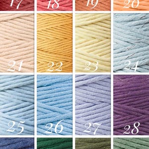May include: A collection of 16 spools of cotton cord in various colors, including red, pink, orange, yellow, blue, purple, green, and brown. The spools are numbered 17 through 32.