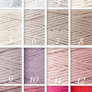 May include: A collection of 16 spools of cotton cord in various shades of white, beige, pink, and red. The spools are arranged in a grid pattern.