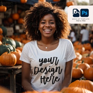 Könnte beinhalten: Eine Frau mit lockigem Haar trägt ein weißes T-Shirt mit dem Text "your design here" darauf. Sie steht vor einem Haufen Kürbisse.