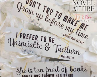 May include: Three white bookmarks with quotes from Louisa May Alcott and Jane Austen. The bookmarks have gold geometric accents and floral designs. The text on the bookmarks reads: "DON'T TRY TO MAKE ME Grow up before my time", "I PREFER TO BE Unsociable & Taciturn", and "She is too fond of books AND IT HAS TURNED HER BRAIN".