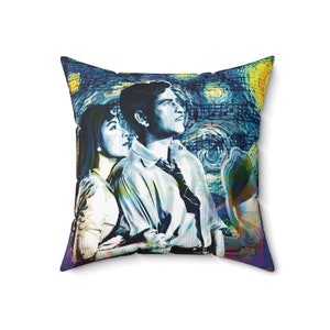 Könnte beinhalten: Ein blaues und gelbes Kissen mit einem Gemälde eines Paares, das in den sternenklaren Nachthimmel blickt. Das Gemälde ist eine Nachbildung von Vincent van Goghs berühmtem Werk "Sternennacht."