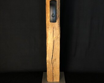 May include: A wooden dispenser stand with a black dispenser mounted in a cutout. The stand is made of reclaimed wood and has a metal base.