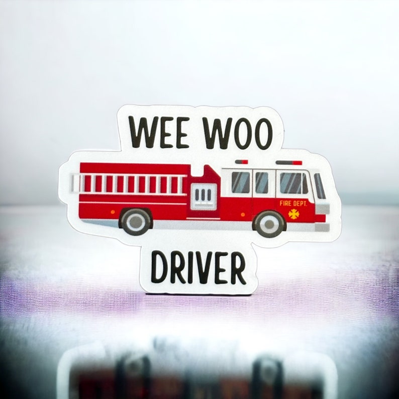 May include: Red and white fire truck sticker with the words "Wee Woo Driver" on it.