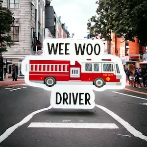 May include: A white sticker with the words "Wee Woo Driver" and a cartoon red fire truck with the words "Fire Dept." on the side.
