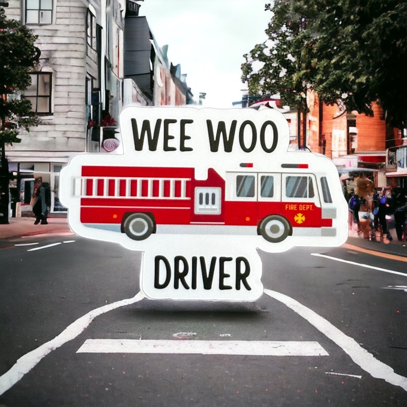 May include: A white sticker with the words "Wee Woo Driver" and a cartoon red fire truck with the words "Fire Dept." on the side.