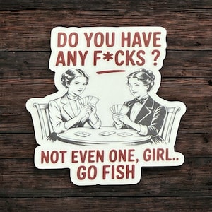 May include: A sticker with a vintage illustration of two women playing cards. The text reads "DO YOU HAVE ANY F*CKS? NOT EVEN ONE, GIRL.. GO FISH" in a bold, red font. The sticker is on a wooden background.