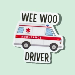 Op de afbeelding: Witte ambulance sticker met rode accenten en de woorden "WEE WOO DRIVER" in zwarte tekst.