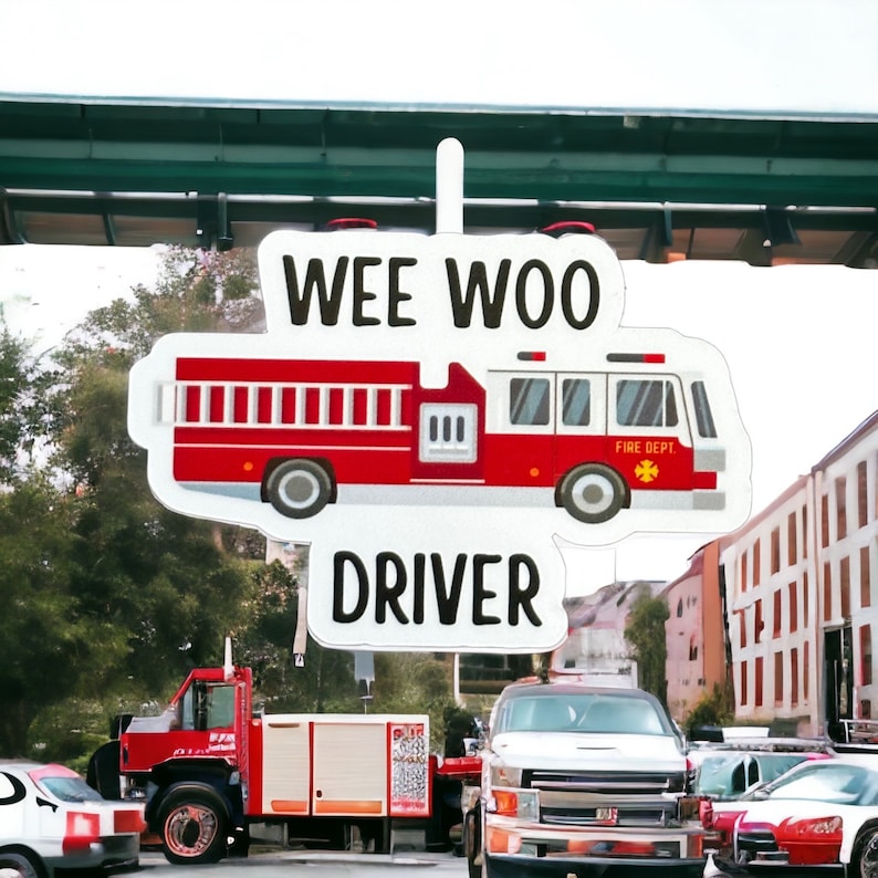May include: A white sticker with the text "Wee Woo Driver" and a cartoon image of a red fire truck with the words "Fire Dept." on the side.
