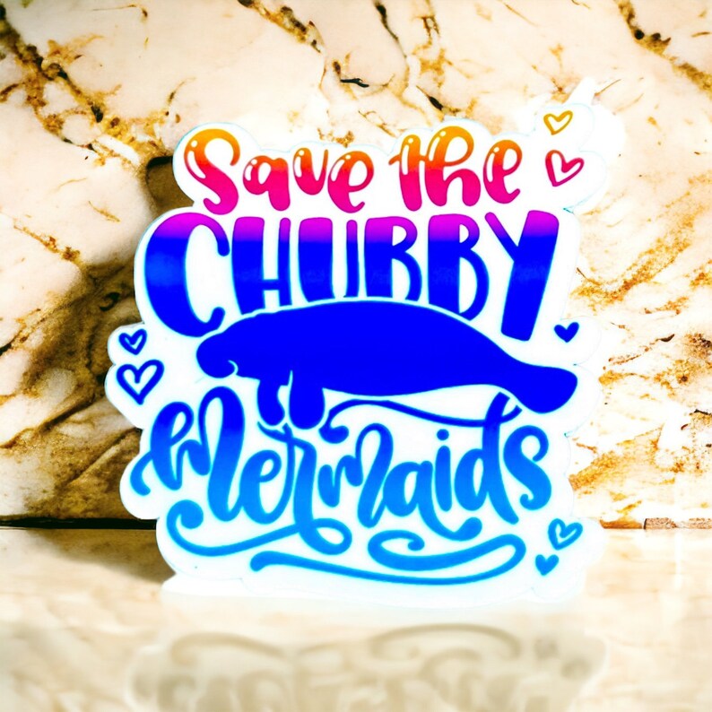 Peut inclure: Un autocollant blanc avec un lamantin bleu et le texte "Save the Chubby Mermaids" en couleurs arc-en-ciel. L'autocollant a de petits c&oelig;urs autour du texte.