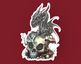 Könnte beinhalten: Ein Aufkleber mit einer detaillierten Illustration eines schwarzen Drachen mit roten Augen, der auf einem Schädel sitzt. Der Drache hat detaillierte Schuppen und Flügel. Der Schädel ist grau mit sichtbaren Zähnen und Augenhöhlen. Der Hintergrund ist weinrot.