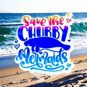 Peut inclure: Un autocollant avec une lamantin bleue et le texte "Save the Chubby Mermaids" en couleurs arc-en-ciel. L'autocollant est sur une plage de sable avec une mer bleue en arri&egrave;re-plan.