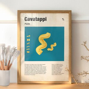 Può includere: Una stampa incorniciata con pasta Cavatappi su sfondo turchese. Il poster include la parola "Cavatappi" in grandi caratteri, con testo più piccolo sotto. Una collezione di utensili da cucina bianchi con manici in legno è in un contenitore bianco.