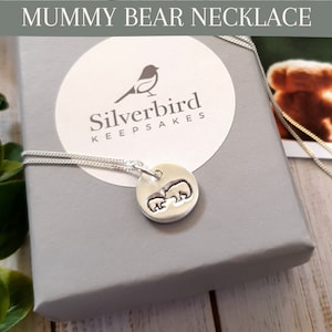 May include: Silver necklace with a silver pendant featuring a mummy bear and baby bear. The necklace is in a grey box with the Silverbird Keepsakes logo.