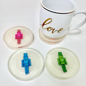 4つのカラフルなくるみ割り人形のクリスマスコースター、透明なエッジの3D樹脂コースターセット。ホステスギフトに最適、ミニマルなプレースセッティング、バーカートの装飾。