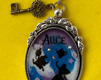 Diseño de resina en espiral de Alicia en el país de las maravillas con estrellas holográficas plateadas y personajes incluidos en un bisel plateado con llavero.