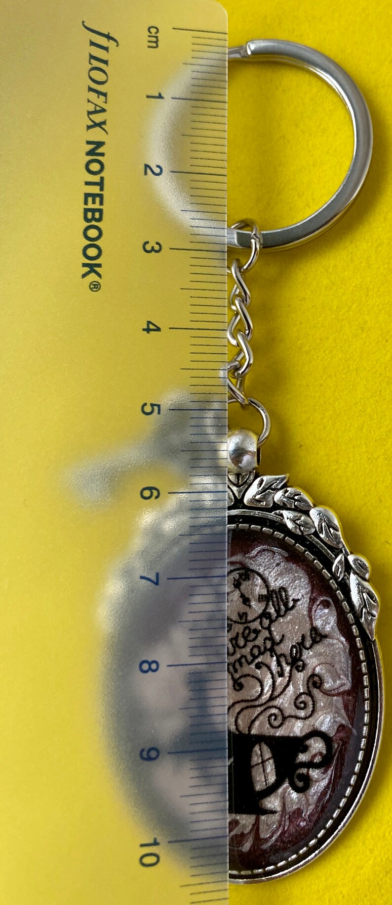 Alice in Wonderland swirling resin design with character inclusion in a Silver Bezel with key charm on Keychain