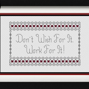 May include: A framed cross-stitch design with a white background and black and red stitching. The design reads "Don't Wish For It. Work For It!"