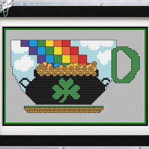 May include: A cross-stitch pattern of a green pot with a shamrock and a rainbow on top. The pot has a handle and is sitting on a gold base.