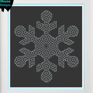 Peut inclure: Un motif de point de croix en forme de flocon de neige blanc sur fond noir, encadré de blanc avec un passe-partout bleu clair.