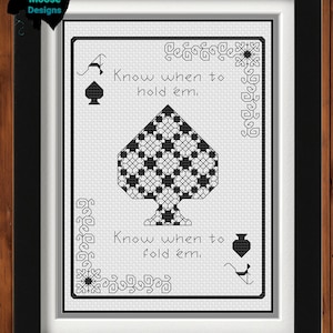 May include: Black and white cross-stitch pattern of an ace of spades playing card with the text "Know when to hold 'em. Know when to fold 'em."