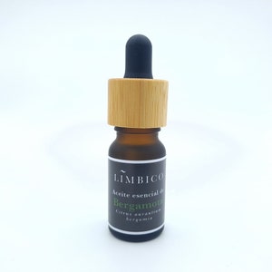 Peut inclure: Une petite bouteille en verre brun avec un compte-gouttes noir et un bouchon en bois. La bouteille est étiquetée "LÍMBICO Aceite esencial de Bergamota Citrus aurantium bergamia".