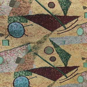 May include: A tapestry fabric with a geometric pattern in shades of brown, green, and blue. The pattern features triangles, circles, and lines.